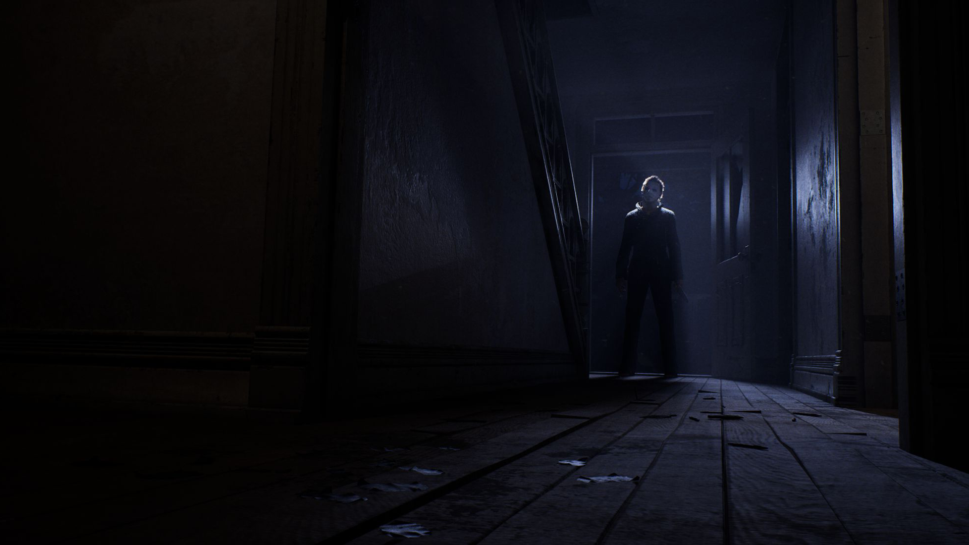 Michael Myers standing at the end of a dark hallway
